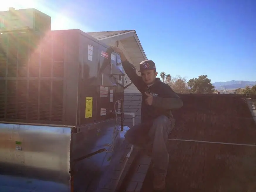 HVAC technician performing Air Duct Repair on a rooftop unit in Baker City